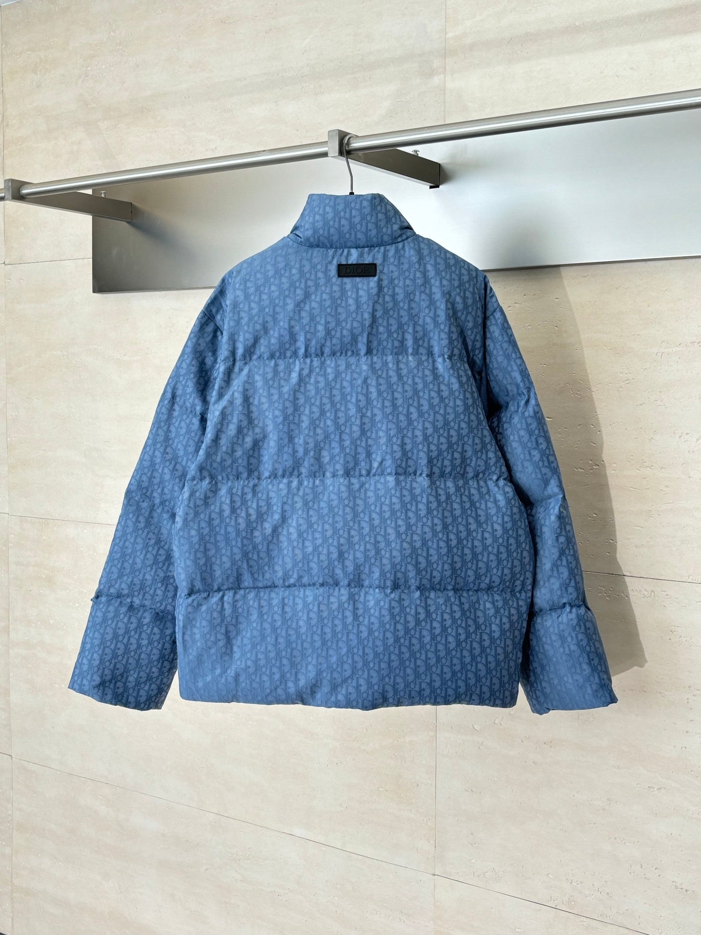Blue Dior puffer jacket back view with standing collar and quilted panels
