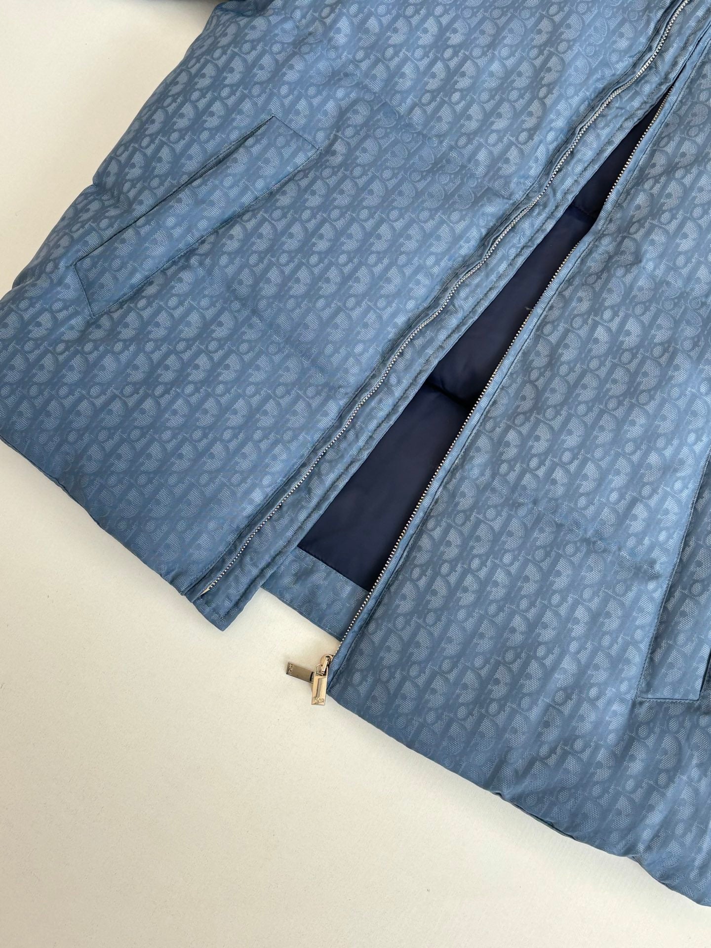 Blue Dior puffer jacket with diagonal zipper and dark interior lining