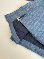 Blue Dior puffer jacket folded with gold zipper pulls and contrast inner panel