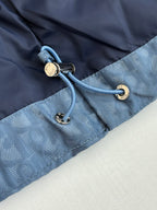 Blue Dior puffer jacket close-up of cord toggles and zipper hardware