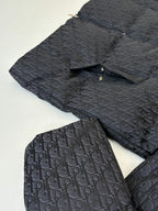 Dior quilted jacket fabric close-up with dark monogram print and visible seam details.