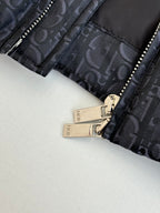 Dior jacket cuff with zipper and metal pull, dark monogram fabric close-up.