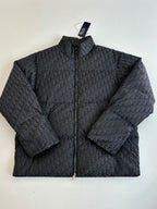 Long quilted Dior jacket with full-zip front and standing collar, dark monogram pattern.