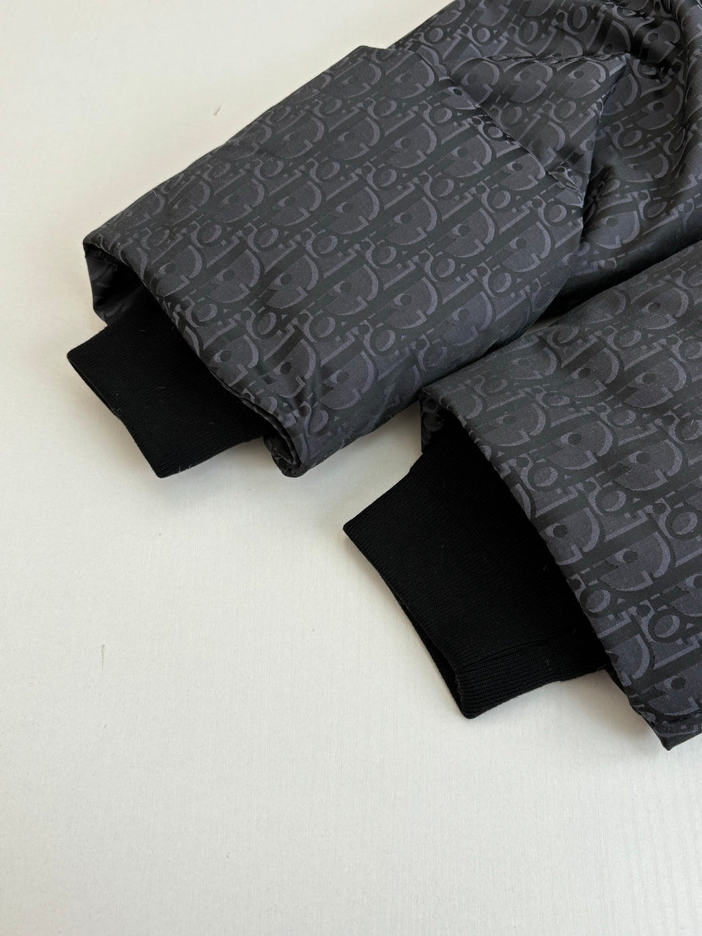 Dior long garment in dark patterned fabric, folded with long sleeves
