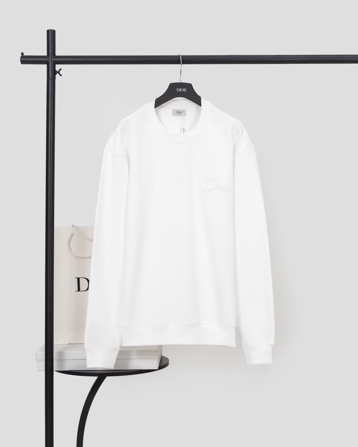White long-sleeve sweatshirt with crew neck and subtle chest logo detail