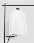 White long-sleeve sweatshirt back view with ribbed cuffs and hem