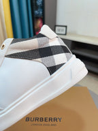 White sneaker with black-and-white plaid strap detail