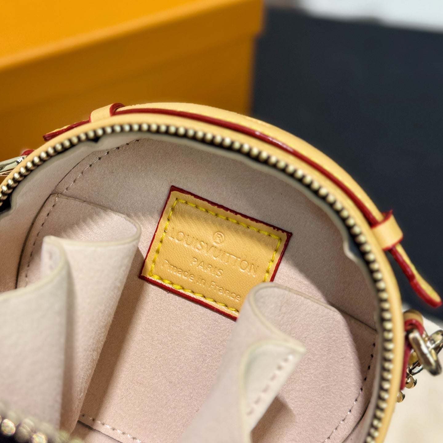 Mini bag interior view with fabric lining and gold label patch near zipper opening