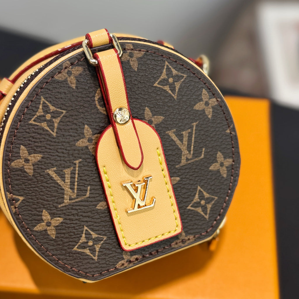 Close-up: round mini bag with brown monogram canvas and tan leather front tag