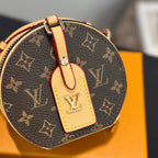 Close-up: round mini bag with brown monogram canvas and tan leather front tag