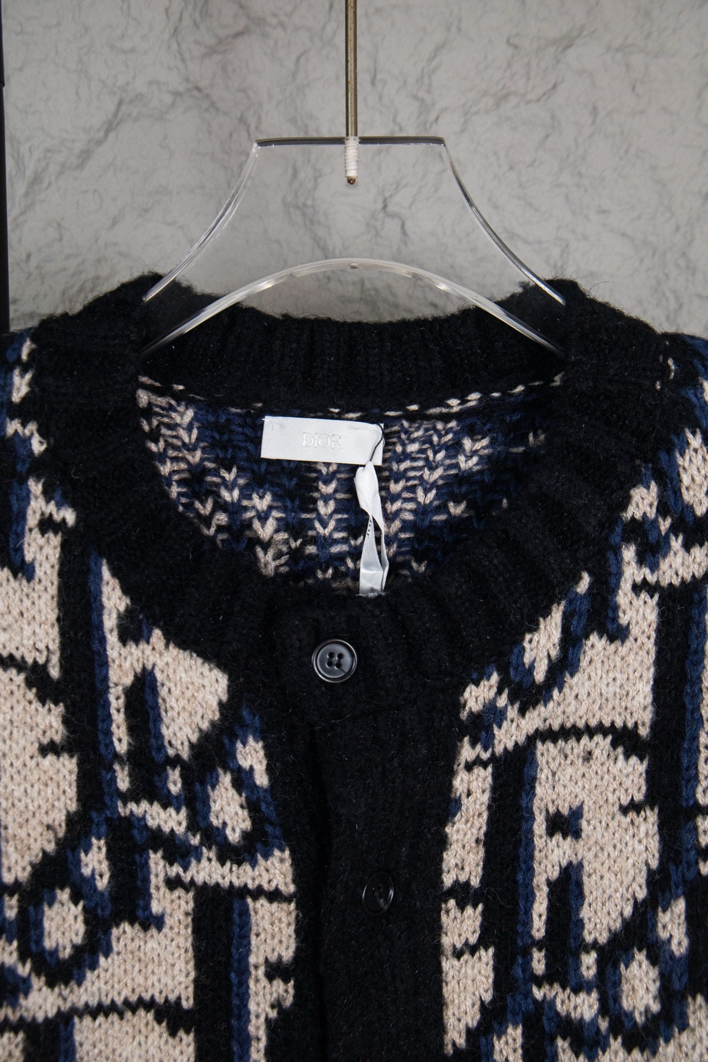 Dior knit cardigan neckline with logo pattern, black placket and visible button.