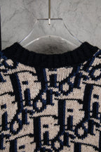 Dior knit cardigan upper back with navy and cream logo-style pattern and ribbed collar.