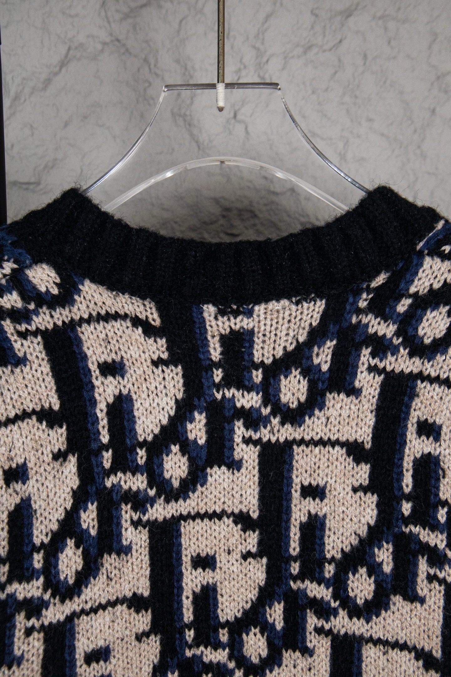 Dior knit cardigan upper back with navy and cream logo-style pattern and ribbed collar.