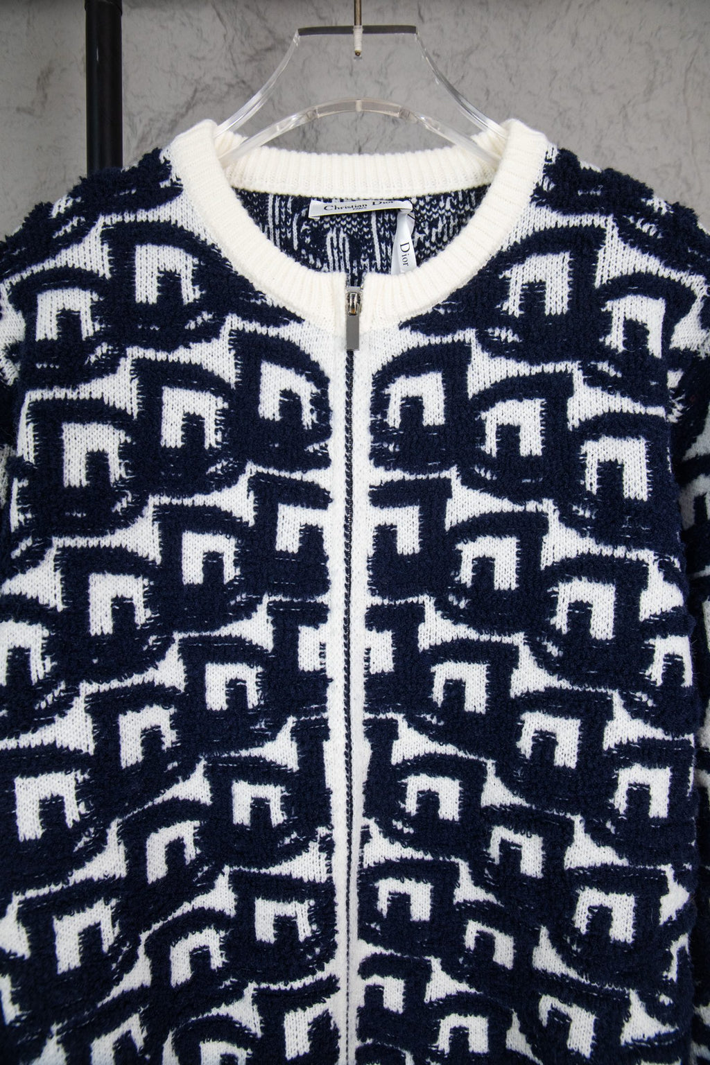 Navy-and-white knit sweater with ribbed collar and zip front, Dior logo pattern.