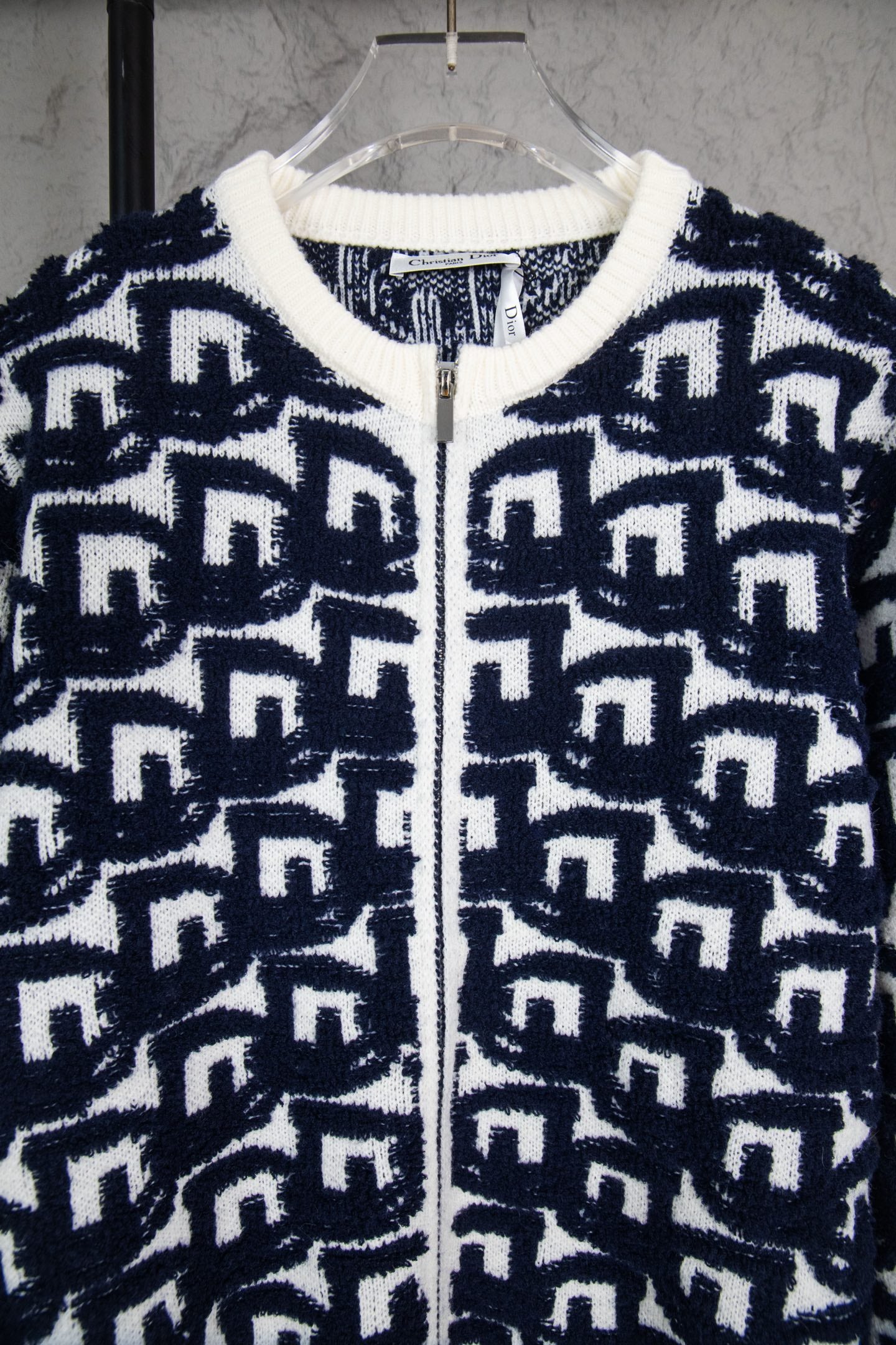 Navy-and-white knit sweater with ribbed collar and zip front, Dior logo pattern.