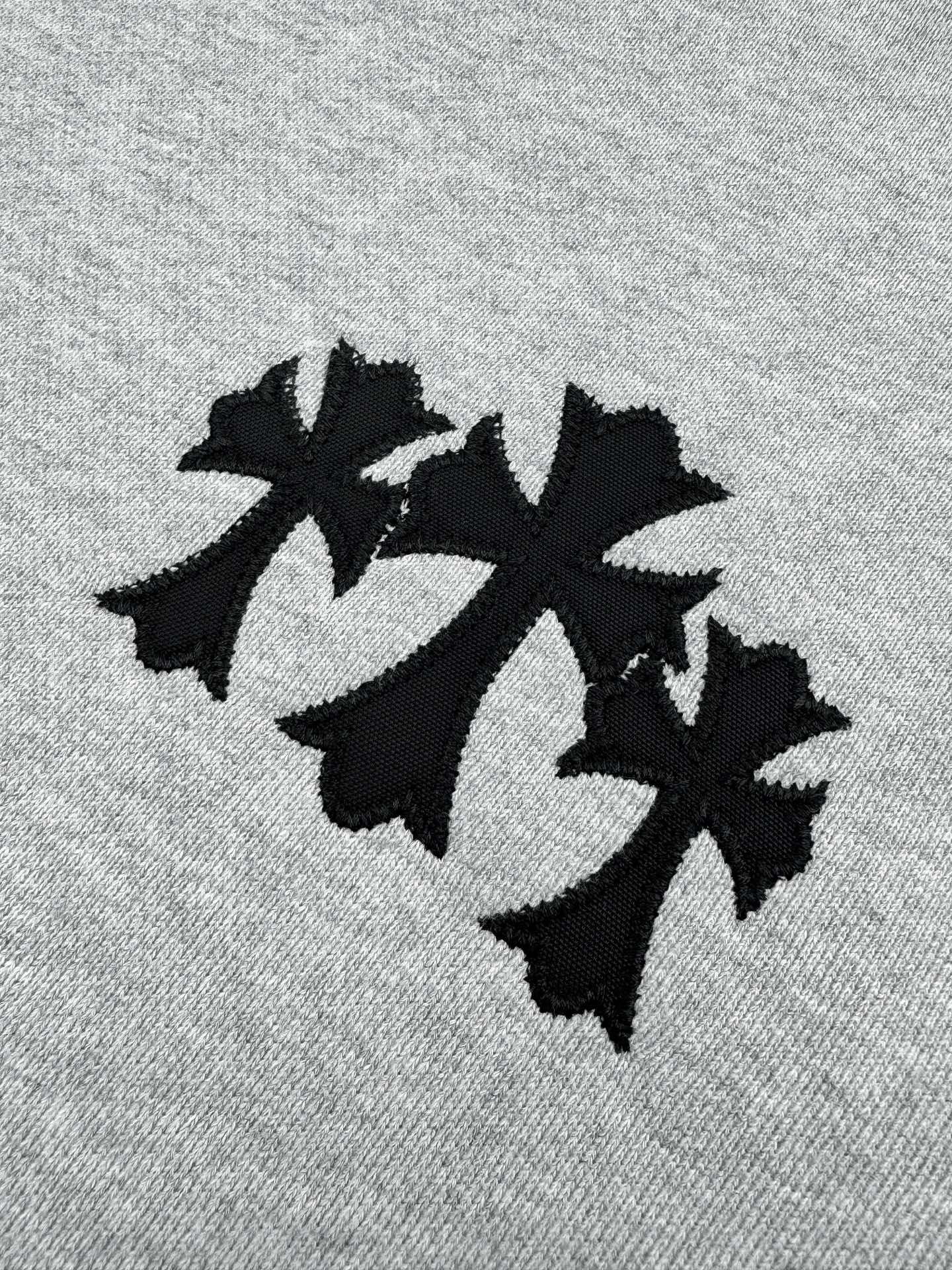 Black leaf-style graphic on heather gray sweatshirt front