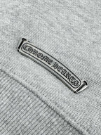 Metallic brand tag on heather gray sweatshirt seam