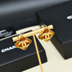 Gold-tone Chanel logo cuff-style earrings with amber enamel and black accents, pair