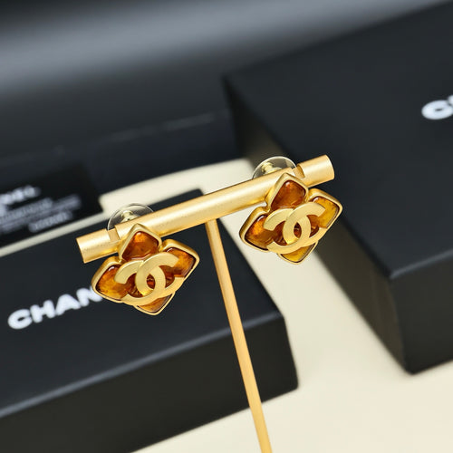 Gold-tone Chanel logo cuff-style earrings with amber enamel and black accents, pair