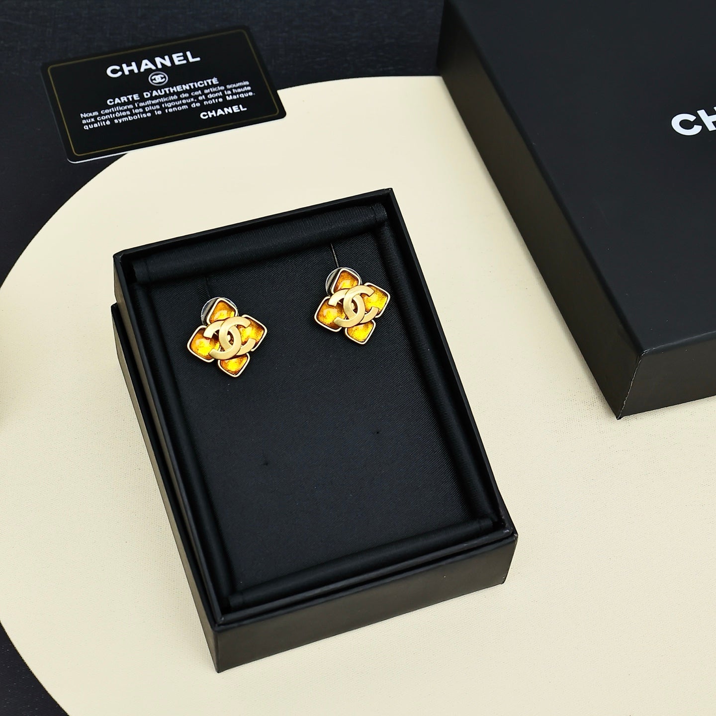 Gold-tone Chanel logo stud earrings in black gift box, amber enamel details