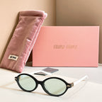 MiuMiu round sunglasses with black frame and light green tinted lenses