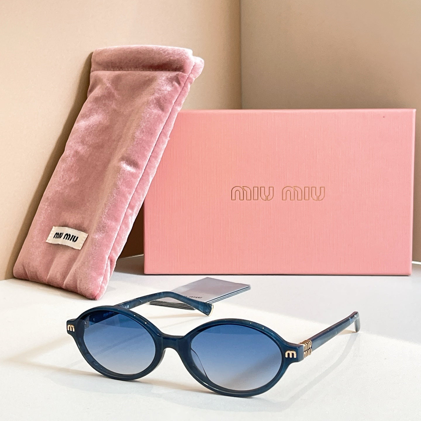MiuMiu round sunglasses with dark frame and blue tinted lenses