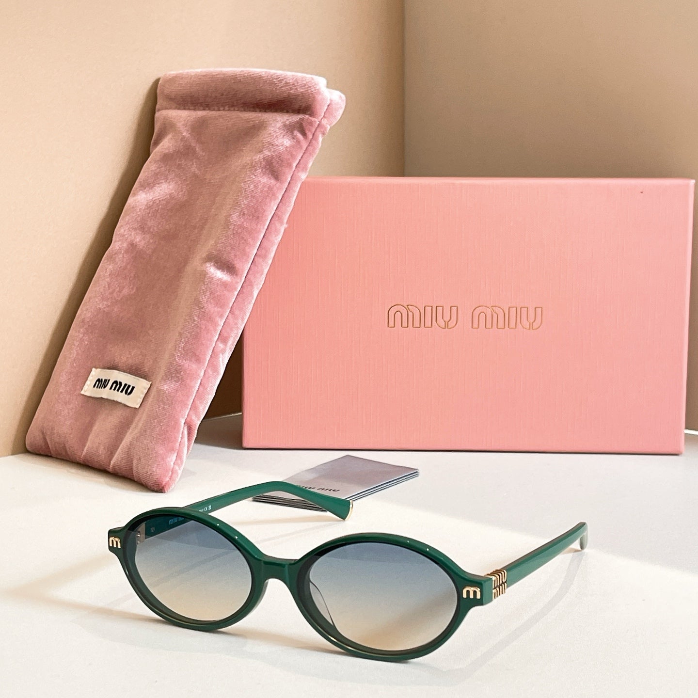 MiuMiu round sunglasses with dark green frame and blue tinted lenses