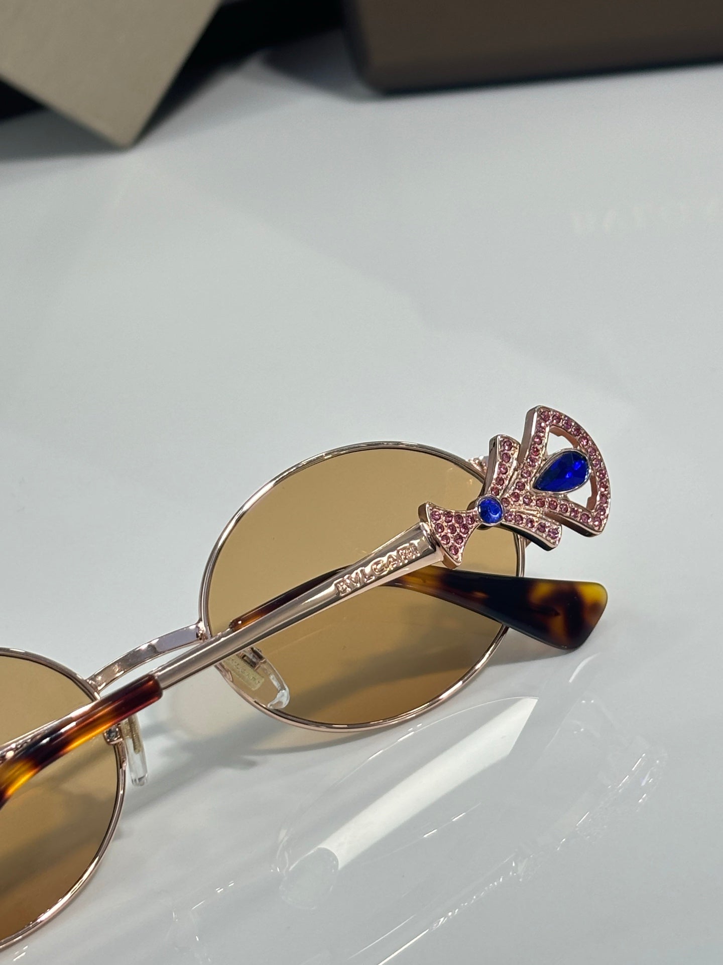 Round sunglasses with tortoiseshell arms, gold frame, amber tinted lenses