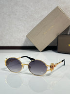 Round sunglasses with gold frame and dark purple tinted lenses