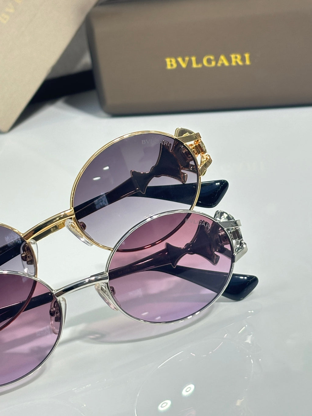 Round sunglasses with gold frames and purple tinted lenses