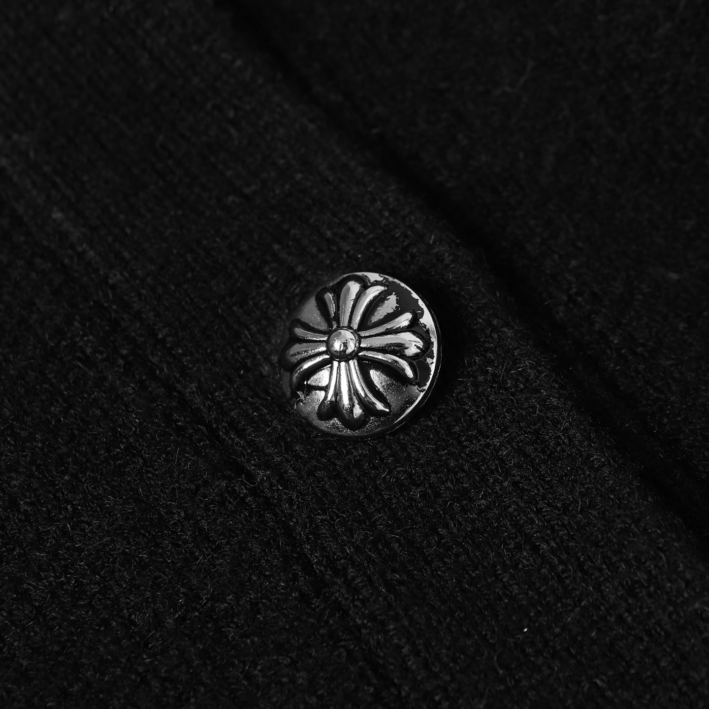 Silver flower-pattern button on black jacket