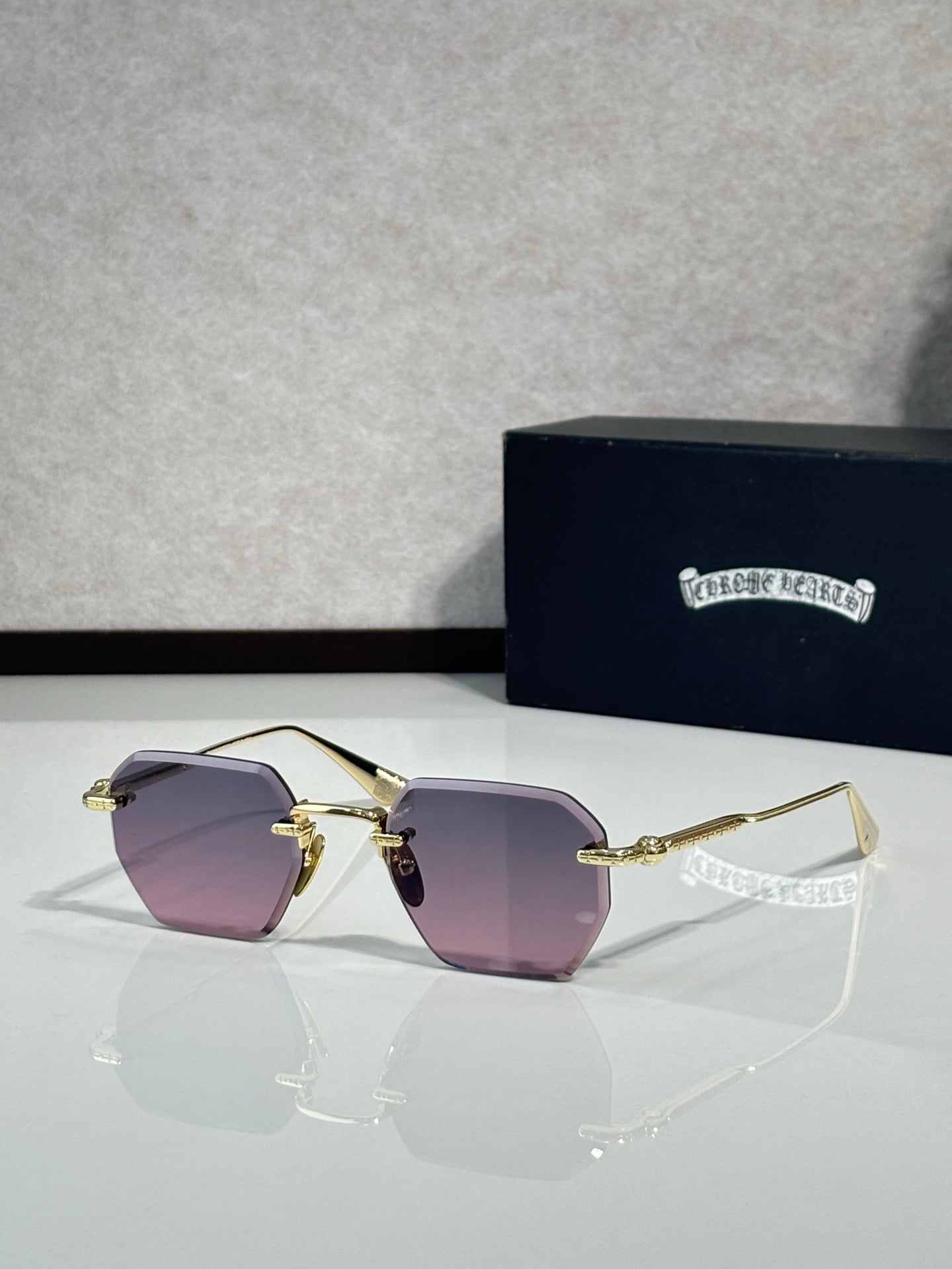 Chrome metal sunglasses with purple tinted lenses and thin gold arms