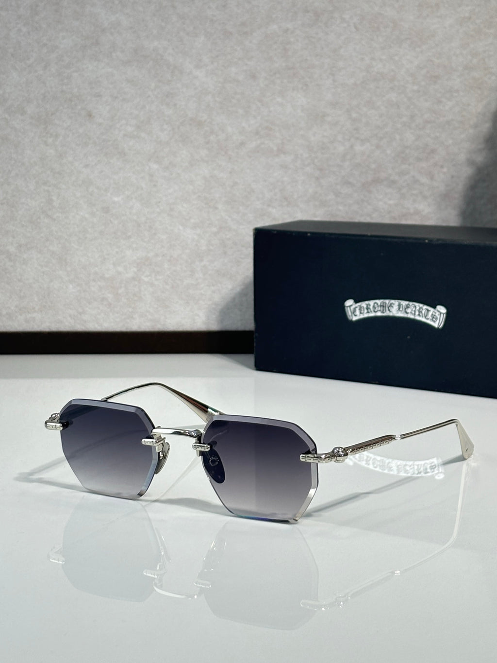 Chrome metal sunglasses with gradient dark lenses and thin gold arms