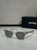 Sunglasses with clear gray frames and dark green lenses, gold hinge detail on temples