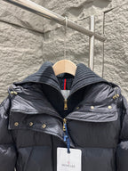 Dark Moncler puffer coat hood close-up with gold buttons and front zipper