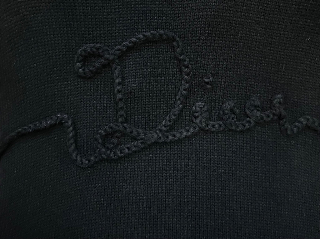 Embroidered script logo detail on black knit sweater chest