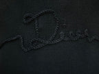 Embroidered script logo detail on black knit sweater chest