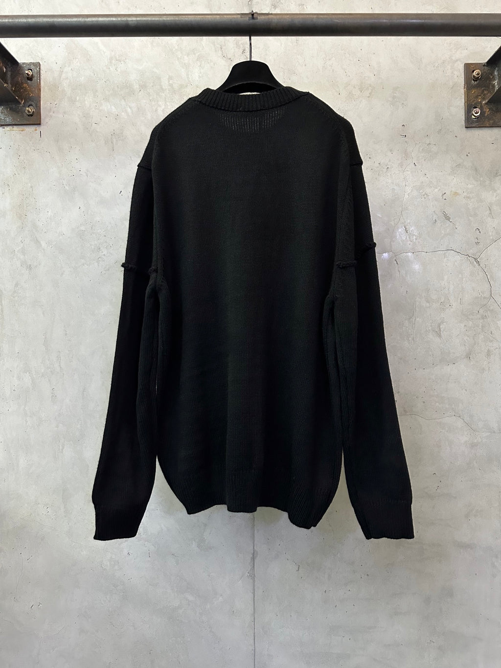 Black long-sleeve knit sweater, back view, crew neckline and shoulder patch detail