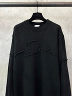 Black knit sweater with crew neck ribbing and prominent embroidered script logo on chest