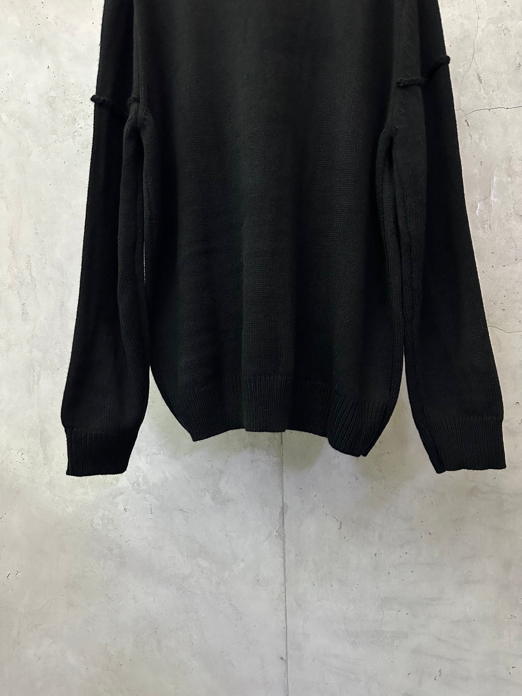 Black knit sweater back view with ribbed hem and long sleeves
