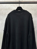 Black knit sweater back view with crew neck ribbing and folded shoulder detail