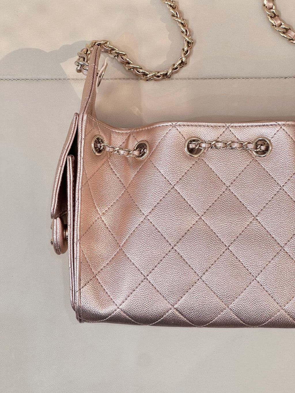 Chanel quilted handbag front panel close-up, rose-pink leather, CC logo and chain detail