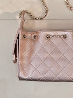 Chanel quilted handbag front panel close-up, rose-pink leather, CC logo and chain detail