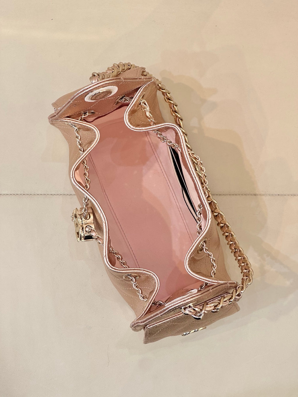 Chanel quilted handbag back view, rose-pink leather, chain strap and clasp top