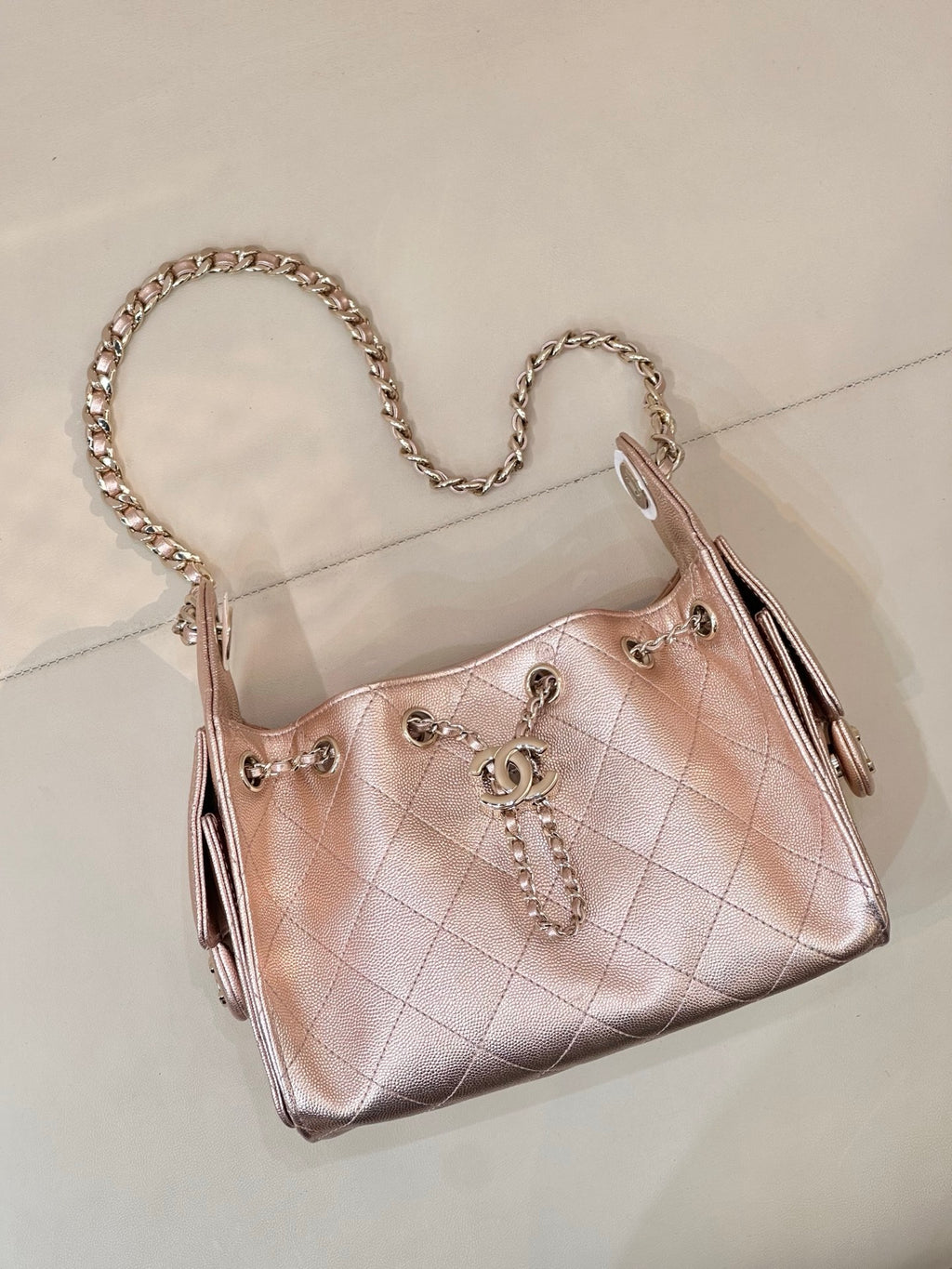 Chanel quilted handbag with chain strap, rose-pink leather, side profile and dangling pull