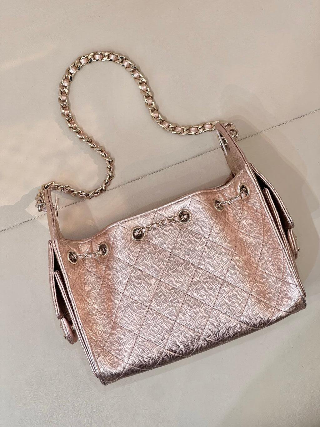 Chanel quilted handbag with chain strap, rose-pink leather, angled side with zipper pulls