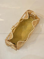 Chanel quilted gold handbag with chain strap and short top handles, side view