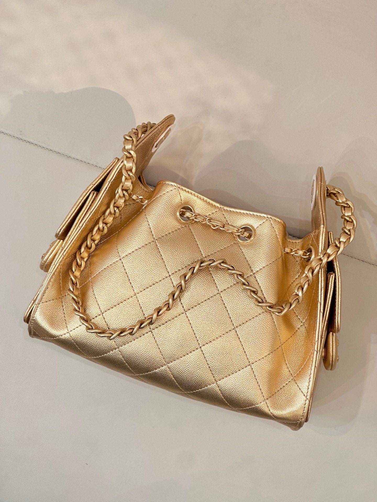 Chanel quilted gold handbag with twisted chain strap and side pull tabs
