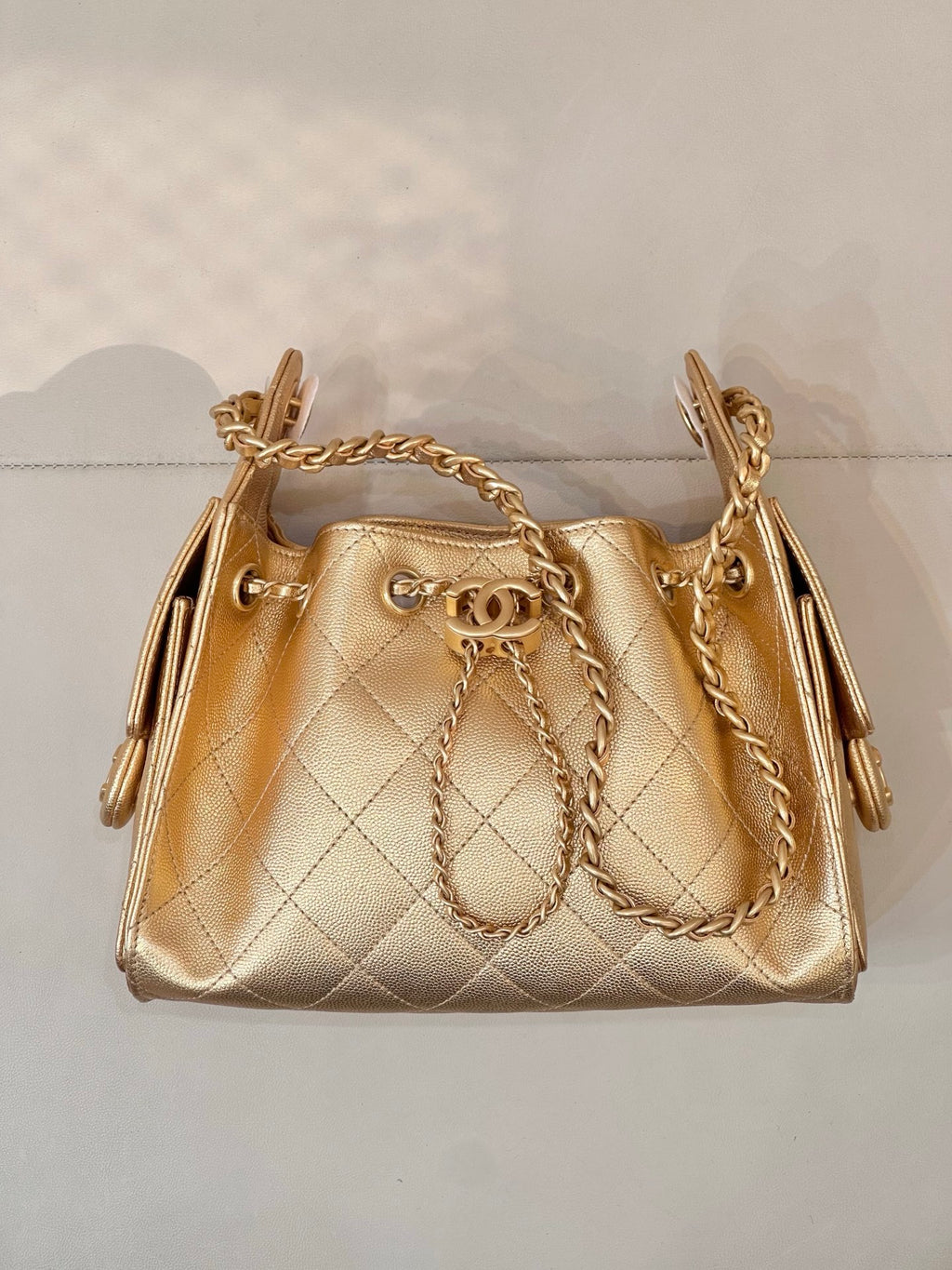 Chanel quilted gold mini handbag with gold chain strap and top hardware detail