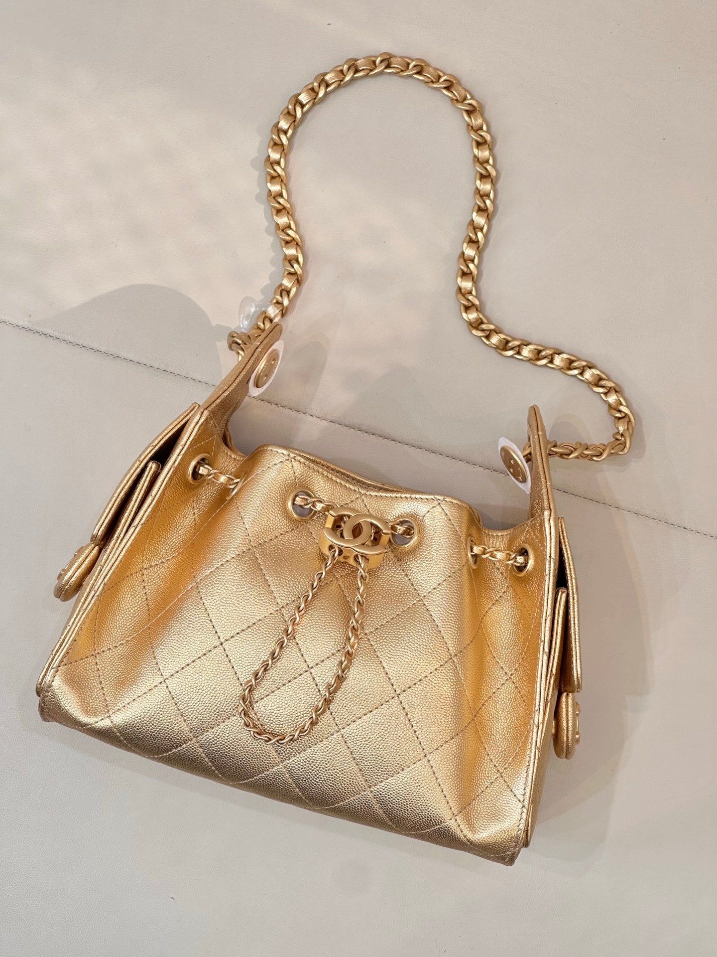 Chanel quilted gold handbag with chain strap, ring clasp front, side pull details